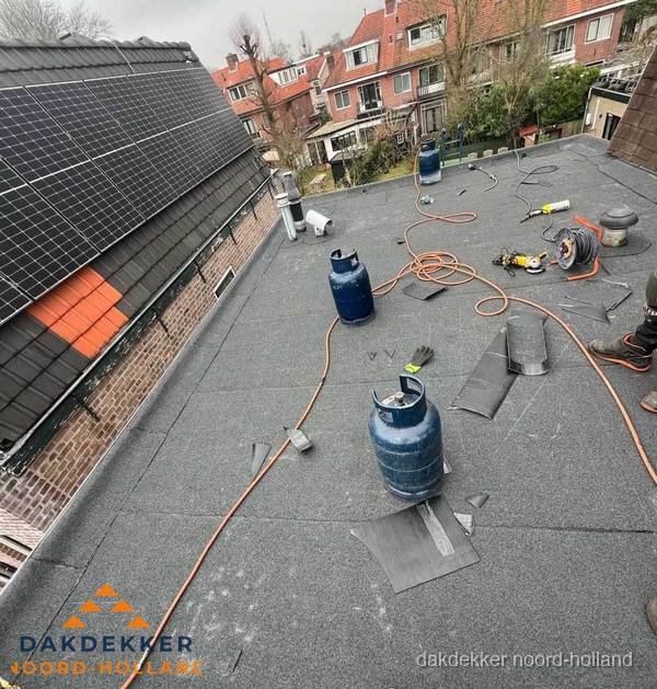 Daklekkage repareren met brandgereedschap op plat dak in Noord-Holland