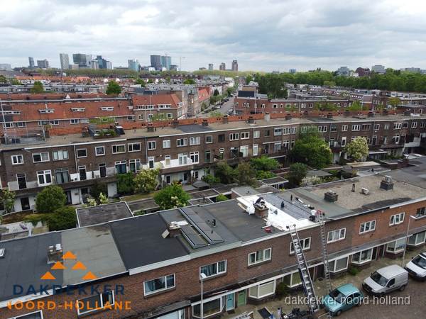Spoed dakdekker aan het werk op plat dak in woonwijk Noord-Holland