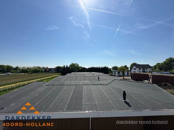 Groot plat dak met bitumen dakbedekking op bedrijfspand in Noord-Holland