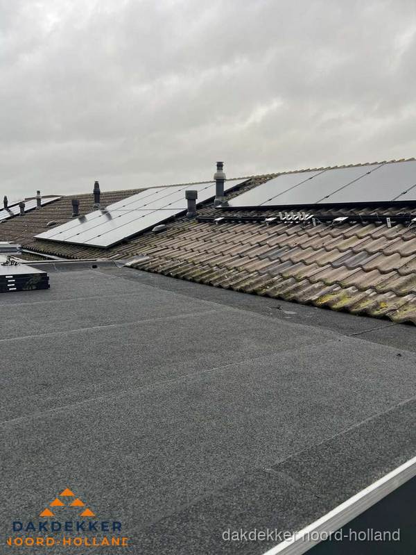 Bitumen dakbedekking op plat dak met aansluitend pannendak en zonnepanelen in Noord-Holland