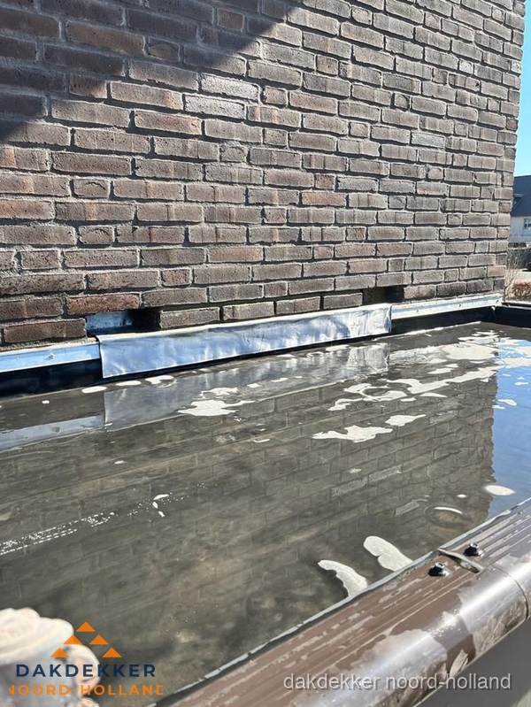 Stilstaand water op plat dak door slechte afwatering in Noord-Holland