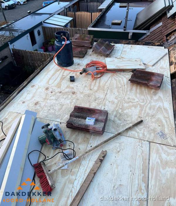 Dakreparatie werkzaamheden op plat dak met gereedschap in Noord-Holland