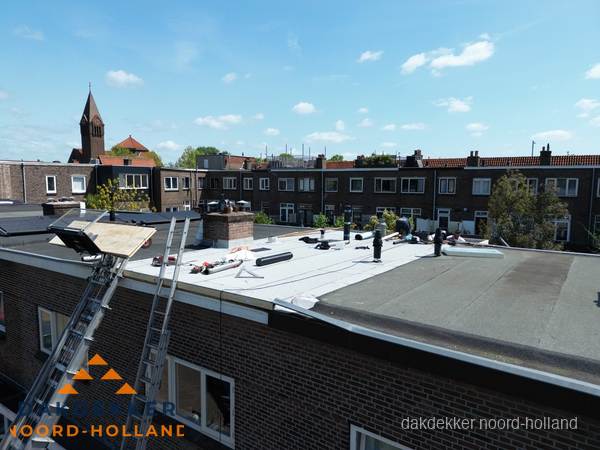 Dakdekkers aan het werk op plat dak in Noord-Holland Dakdekkers aan het werk op plat dak in Noord-Holland