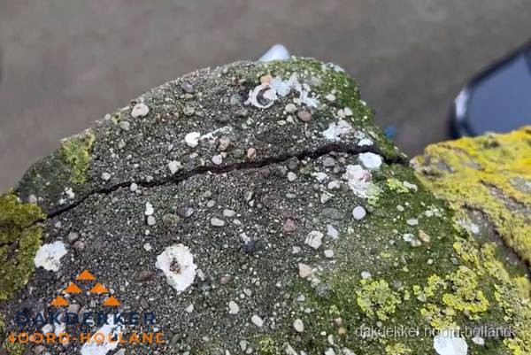Beschadigde en verweerde nokvorst met scheuren en mos in Noord-Holland