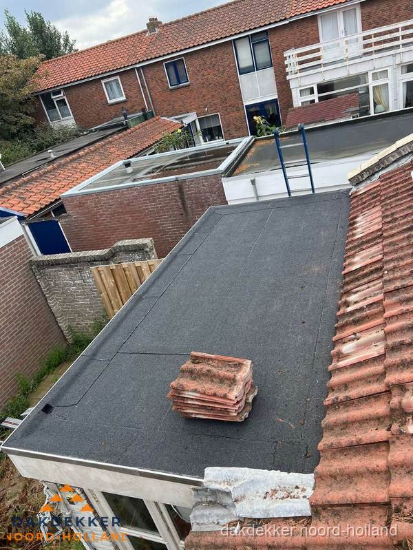 Aanbouw plat dak met reservepannen voor dakpannen vervangen in Noord-Holland