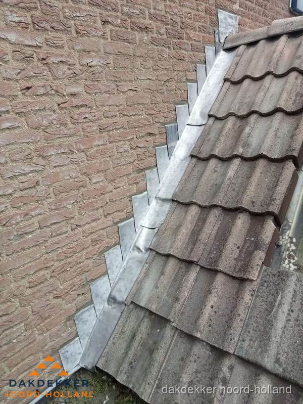 Loodslabben langs dakaansluiting bij bakstenen muur in Noord-Holland