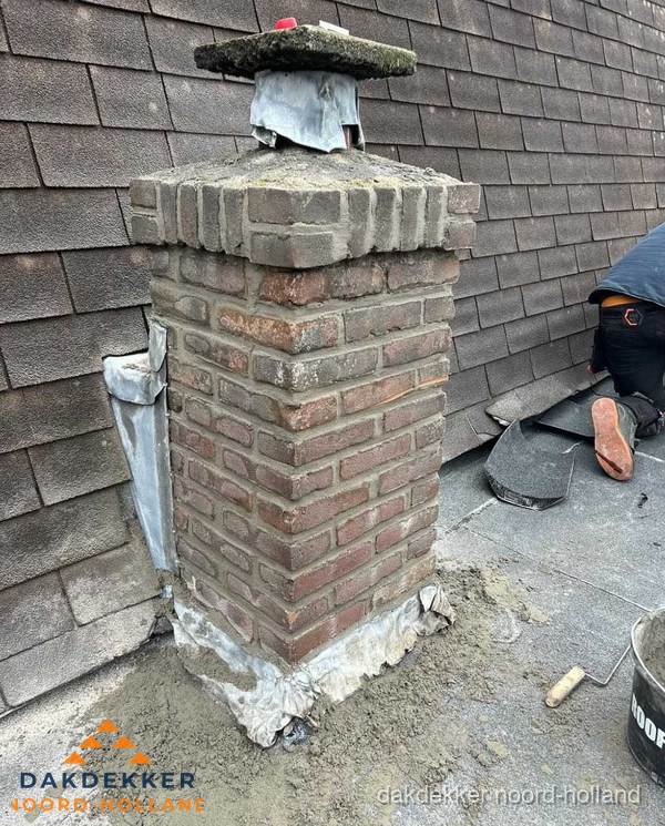 Schoorsteen reparatie met lood en voegwerk op leien dak in Noord-Holland