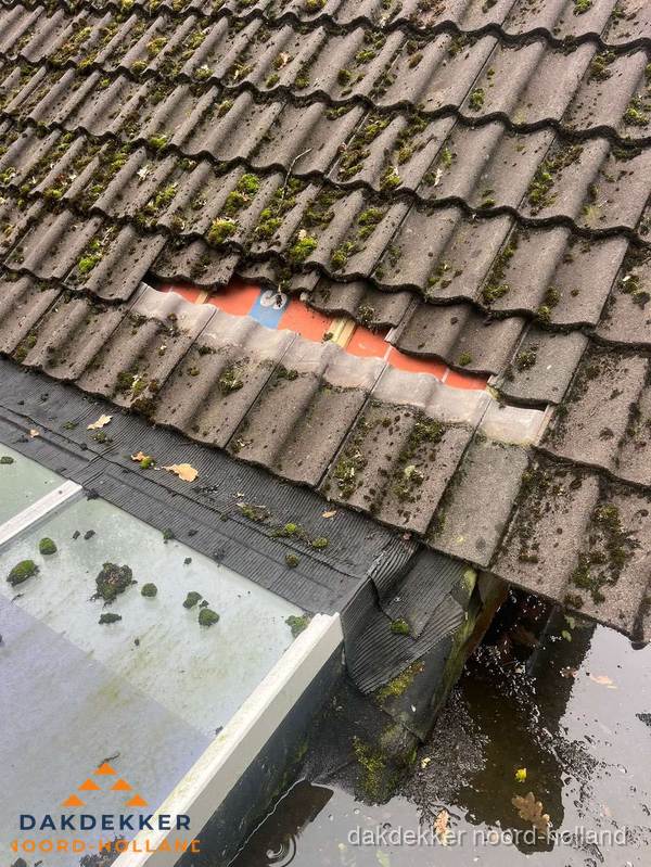 Beschadigd pannendak met ontbrekende dakpannen voor reparatie in Noord-Holland