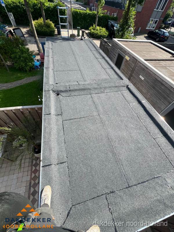 Bitumen plat dak rijtjeswoning vanuit dakdekker perspectief in Noord-Holland