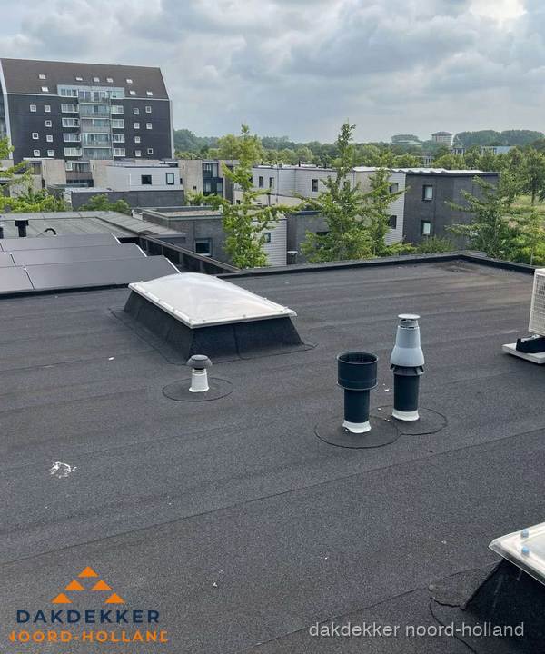 Groot plat dak met lichtkoepel en dakdoorvoeren in Noord-Holland