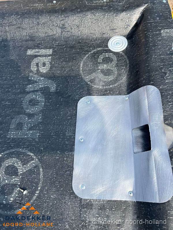Dakdoorvoer met metalen afvoerplaat op bitumen dak in Noord-Holland