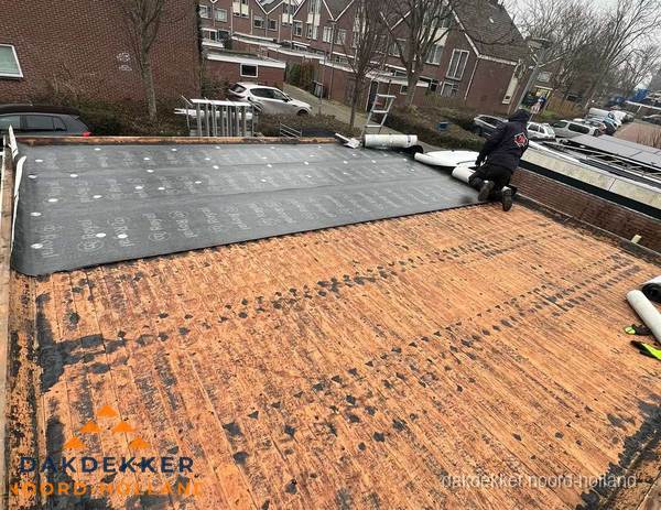 Dakdekker legt onderlaag op plat dak met houten constructie in Noord-Holland Dakdekker legt onderlaag op plat dak met houten constructie in Noord-Holland