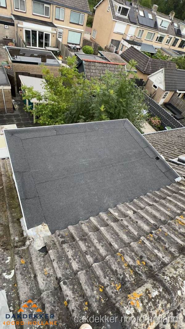 Plat dak aanbouw met bitumen dakbedekking in woonwijk Noord-Holland